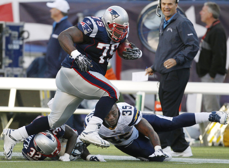 Patriots defensive lineman Vince Wilfork rumbles past San Diego running back Mike Tolbert on his 28-yard return after intercepting Chargers quarterback Philip Rivers’ pass Sunday in Foxborough, Mass. The play set up a 47-yard field goal and a 13-0 Patriots lead.