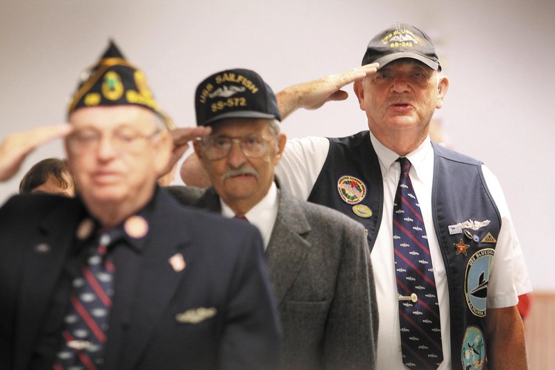 John McCutcheon, right, of Fairfield joins Norman McLeod, center, of Portland and Lyle Grindle, left, of Dedham in reciting the Pledge of Allegiance during an induction ceremony into the Holland Club for having attained 50 years since first qualifying to serve on submarines, at the American Legion Post 205 in Augusta on Sunday.