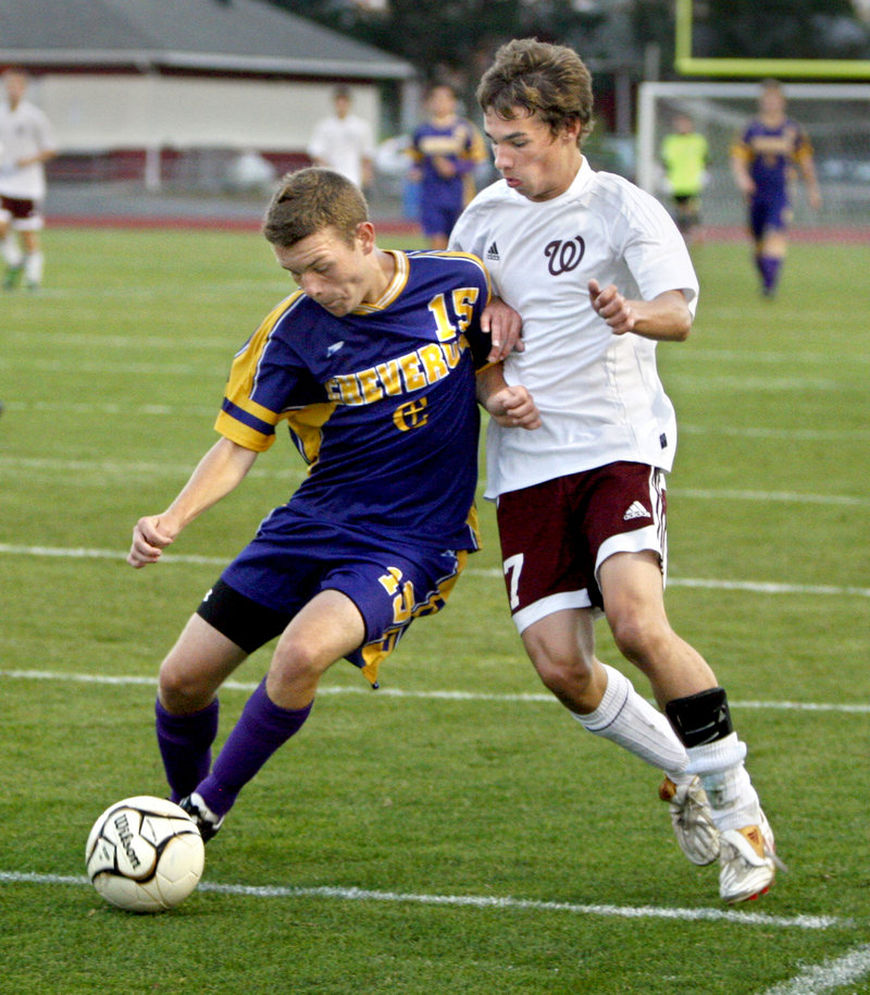 Nate Palmer of Cheverus attempts to control the ball while holding off Marc Reynolds of Windham during Cheverus’ 2-0 victory Tuesday night at Windham High.