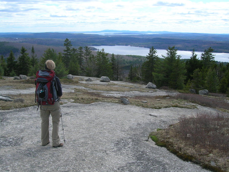A hiker atop Flag Hill takes in the view across Branch Lake below, one of several impressive vistas in Great Pond Mountain Wildlands in East Orland, between Bucksport and Ellsworth.