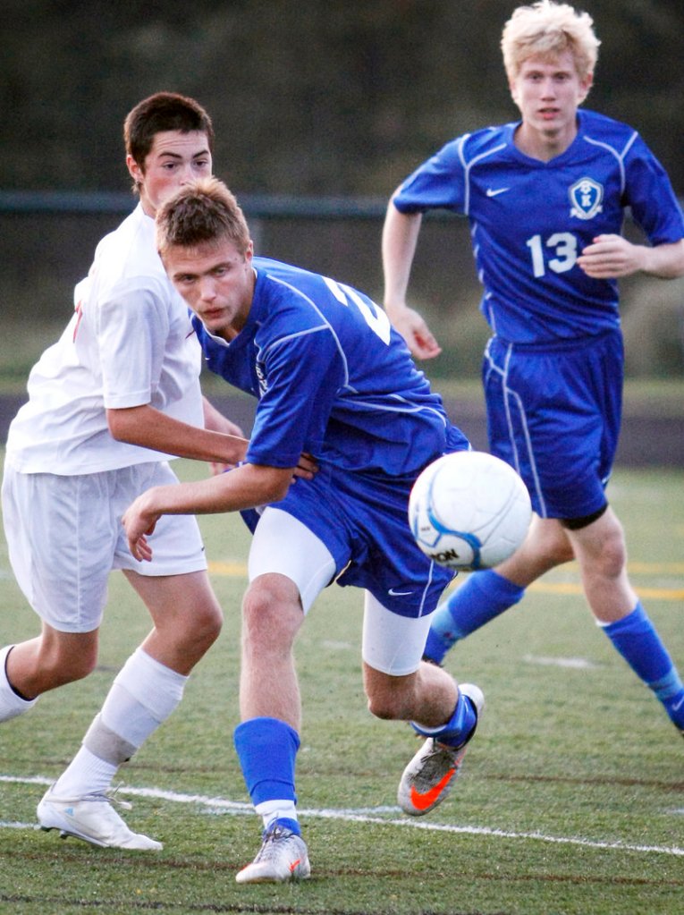 Jacob Jorgensen of Kennebunk pushes past Sam Cekada of Scarborough as Jake Lary of Kennebunk follows the play Wednesday night during their 1-1 tie in a Western Class A schoolboy soccer game at Scarborough.
