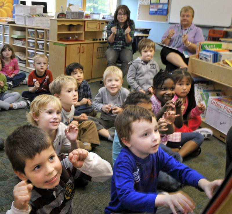 Kindergarten students at Ocean Avenue Elementary School listen Thursday as teacher Juanita DeWitt reads a story. The school’s four kindergarten classes average 22 students, more than the 16 to 20 recommended in district guidelines.