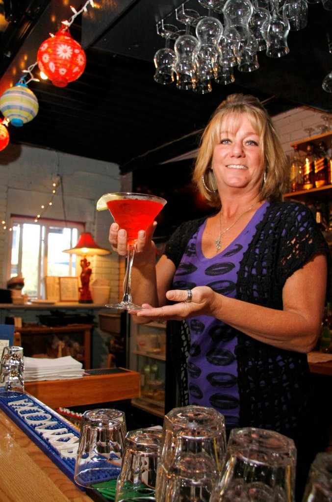 Linda Gaudet serves a cocktail at Jumpin' Jakes Seafood Cafe, where the weekday happy hours are a real treat.