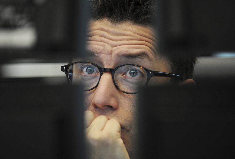 A trader watches his screens at the German stock exchange in Frankfurt on Friday. An action plan unveiled by the G-20 countries Thursday to help Greece avoid a destabilizing default did not immediately soothe fearful investors.