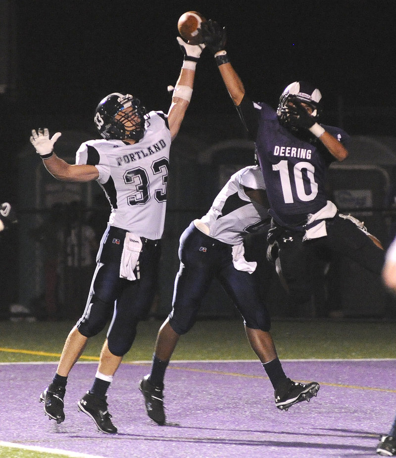 Mike Herrick, left, of Portland breaks up a pass intended for Renaldo Lowry of Deering during their football game Friday night. Deering remained unbeaten with a 28-7 victory.