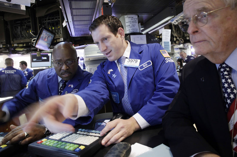 Barclays Capital employees Vincent Folds, left, William Bott, center, and James Maguire work at the New York Stock Exchange on Friday, when the Dow Jones industrial average rose 37.65 points.