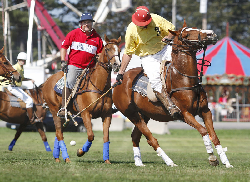 Oliver Keithly of South Portland watches as Gary Sturtevant of Cumberland advances the ball during a demonstration by the Down East Polo Club at the Cumberland County Fair on Sunday. The fair continues through Saturday.