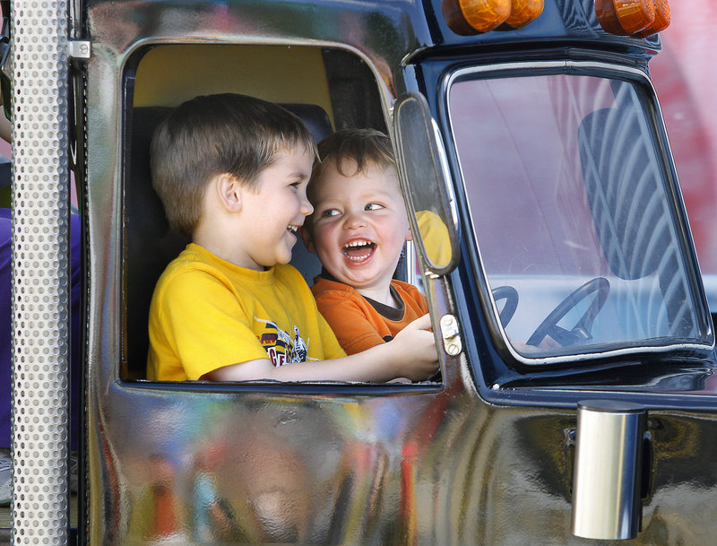 Logan Plourde, 5, of Scarborough, left, and Jack Mesires, 2, of Gorham find reason to laugh on one of the kiddie rides at the Cumberland County Fair on Sunday.