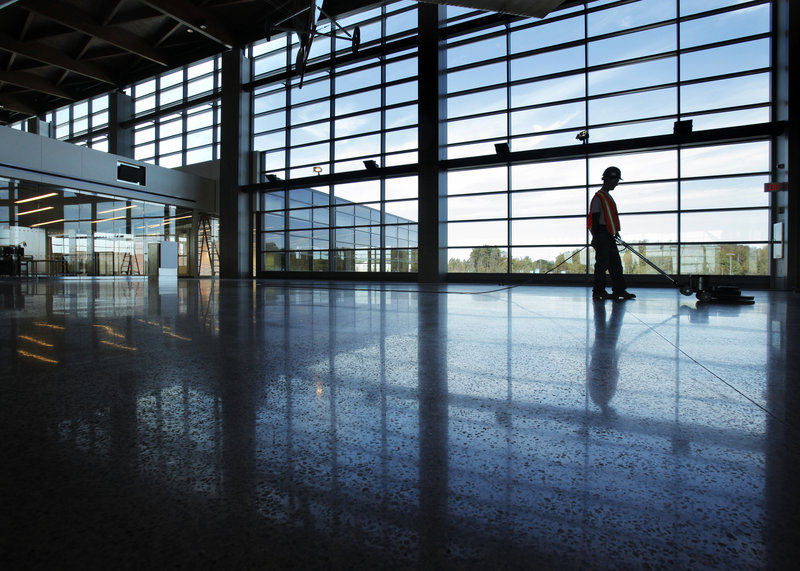 Ed Polinsky runs a floor polisher inside the new terminal at the Portland International Jetport. The terminal aims to blend Maine aesthetics with urban amenities. The public can visit on Saturday.