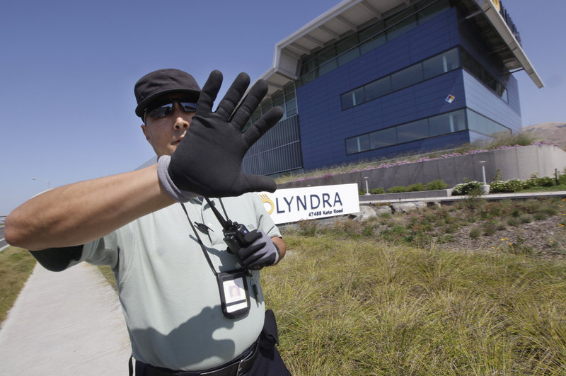 A security guard tries to block a photographer’s view of the Solyndra building in Fremont, Calif., earlier this month. The company’s cylindrical solar panels riveted investors, but sinking worldwide demand and competition from heavily subsidized Chinese flat-panel manufacturers pushed Solyndra into bankruptcy.