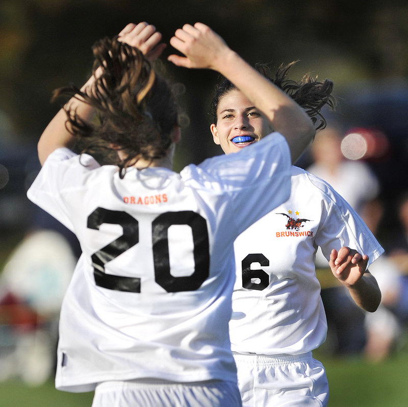 Dakota Foster, 20, of Brunswick celebrates with Cassandra Murano after scoring one of her three goals Tuesday in a 5-0 victory against Messalonskee.