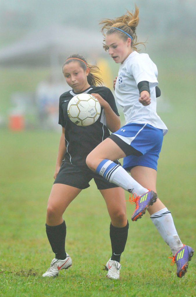 Olivia Dubois of Old Orchard Beach, right, knocks down a pass with her knee Thursday while defended by Hannah Twombly of North Yarmouth Academy. Old Orchard won, 5-0.