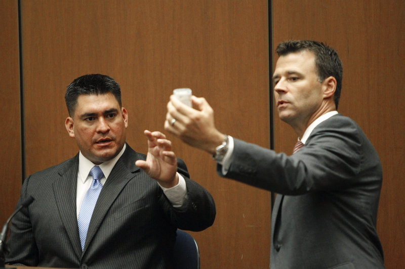 Deputy District Attorney David Walgren holds a bottle of propofol while questioning Alberto Alvarez, one of Michael Jackson’s security guards, during Conrad Murray’s involuntary manslaughter trial Thursday.