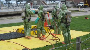 Members of the decontamination team work on the scene at Portland’s wastewater treatment plant late Tuesday afternoon.