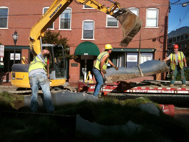 Chris Portell of Coastal Lawncare removes a section of "Tracing the Fore" on Fore Street in Portland this morning.