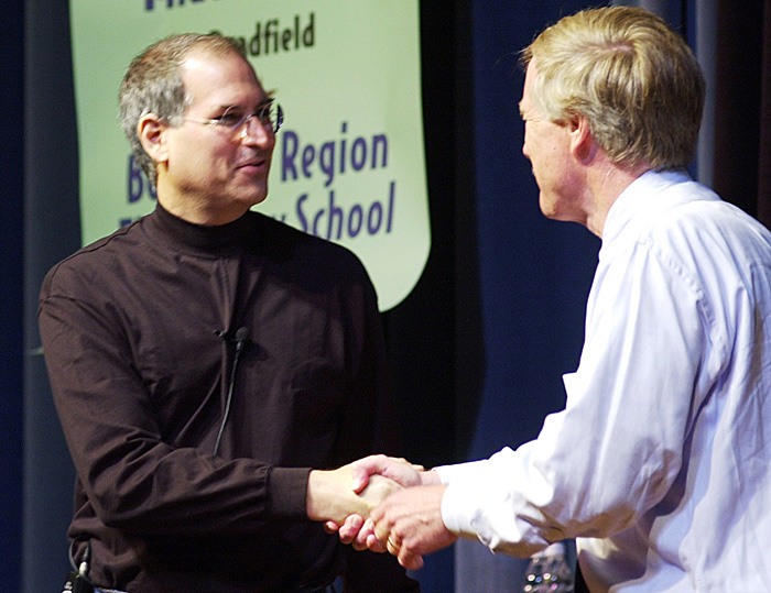 In this June 10, 2002, Steve Jobs, founder and then-president of Apple Computer is greeted by Gov. Angus King as he is introduced at the governor's laptop computer assessment program before educators, legislators, students and others at Portland High School. Apple ibook laptops were the exclusive laptops bought for the students and Apple provided financial and technical support for the program.