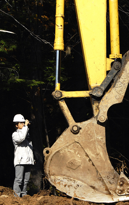 Ohchi Shunsuke photographs a bucket loader Monday. In Miyazaki Prefecture, on the island of Kyushu, loggers harvest the evergreen Cyryptomeria Japonica, known as sugi, and the cypress Chamaecyparis obtusa, known as hinoki, which are used for housing. Miyazaki foresters have to deal with soggy conditions because the average annual rainfall is 138 inches.