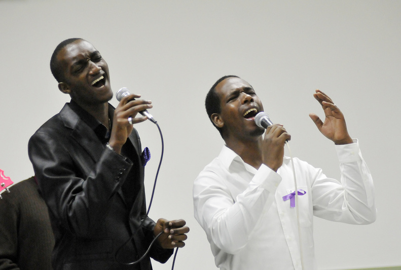 Junior Nubu, left, and Bienvenue Tutabara sing during a memorial service Sunday at the St. Pius X Parish Hall in Portland for the seven Tutsi, or Banyamulenge, humanitarian aid workers who were killed in the Congolese province of South Kivu this month. Similar services were held around the world.