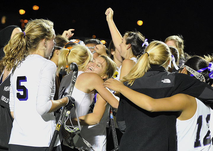 Marshwood High School’s Hailey Bruno-Moulton, center, hugs Emily Osborne just after their field hockey team’s 4-1 victory over Portland in the Class A Western Maine Regional Final on Tuesday night at Hill Stadium in Saco. York High School won the Class B title over Mountain Valley, and North Yarmouth Academy beat Sacopee Valley in Class C.