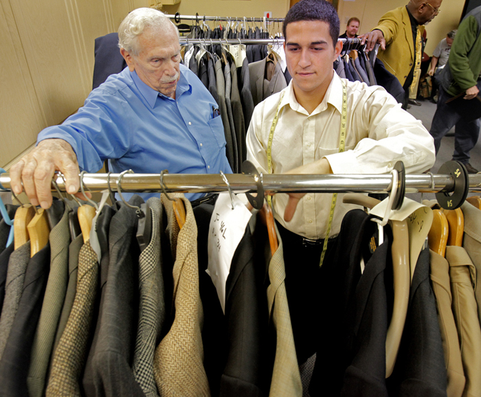 Aaron Dalpe, right, looks for a suit coat for John Corsa during the National Suit Drive at the Career Center in Portland on Tuesday.