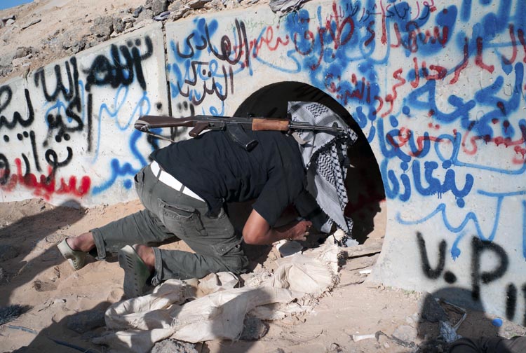 A revolutionary Libyan fighter inspects the tunnels where Moammar Gadhafi is claimed to have been found, in Sirte, Libya, today.