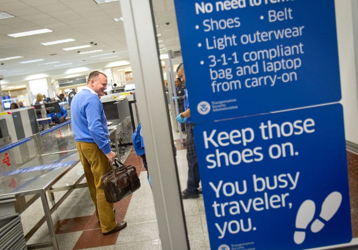 A passenger smiles as he is told by TSA officers that he doesn't need to remove his shoes while going through a new expedited security line today at Hartsfield-Jackson International Airport in Atlanta.