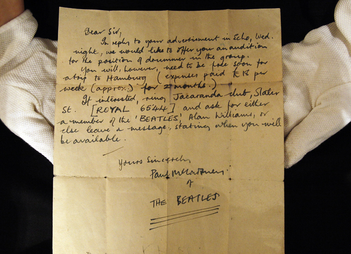 A Christie's employee displays a letter inviting an unknown drummer to audition for The Beatles.