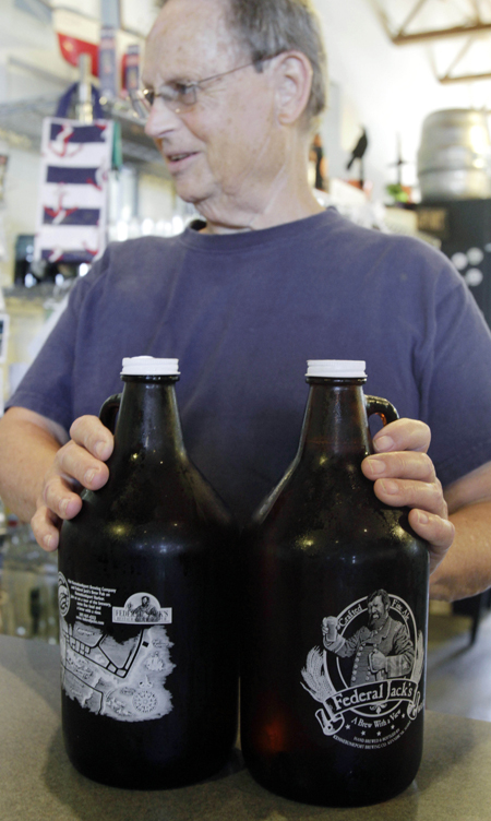 A customer sets two Federal Jack's growlers on a counter to purchase in Kennebunk.