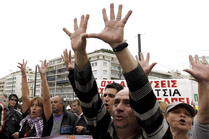 Civil servants gesture toward the Greek parliament during a protest in Athens today. Greece's international debt inspectors have completed their review of the government's reforms, saying today that if their conclusions are adopted by the eurozone and IMF, Athens is likely to receive the next batch of its bailout loans in early November.