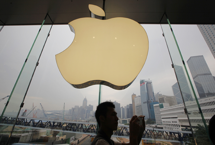 A customer walks past a huge Apple logo at a new store in Hong Kong.