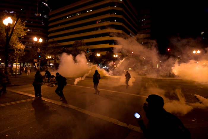 Occupy Wall Street protesters run from tear gas deployed by police at 14th Street and Broadway in Oakland, Calif., on Tuesday.
