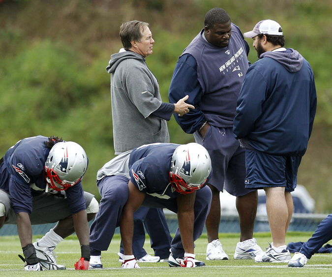 New England Patriots head coach Bill Belichick talks with defensive line coach Pepper Johnson, second right, and safeties coach Matt Patricia during a football practice on Wednesday in Foxborough, Mass.