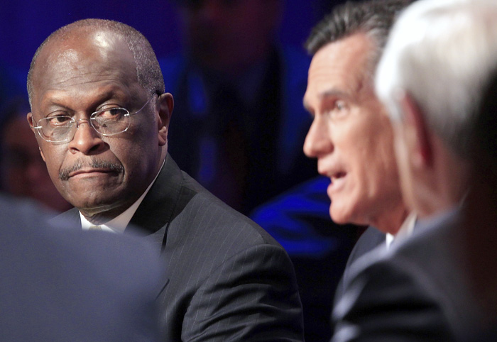 Republican presidential candidate businessman Herman Cain, and Rep. Ron Paul, R-Texas, right, listen as former Massachusetts Gov. Mitt Romney speaks during the Republican presidential debate at Dartmouth College in Hanover, N.H., on Tuesday.