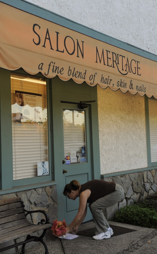 A woman places flowers Thursday in front of the salon in Seal Beach, Calif., where eight people were shot and killed Wednesday. Police arrested Scott Dekraai about a half-mile from the scene.