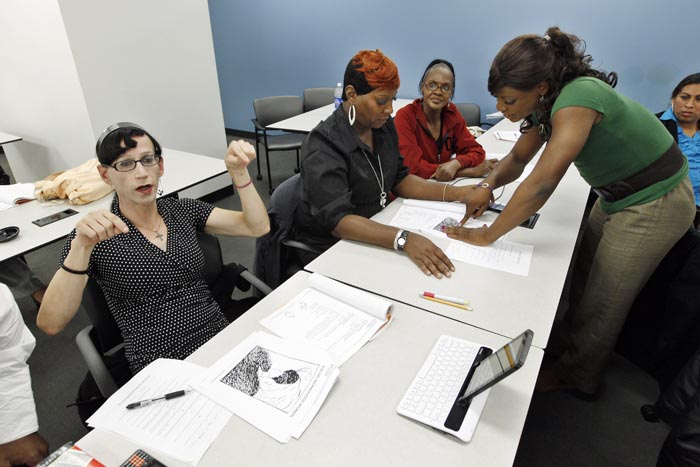 Courtney Phillips, left, participates in class during the Project Empowerment workshop at the Department of Employment Services in Washington. At right is Arriel Michelle Williams, who is in the early stages of a painstaking physical transformation from man to woman.