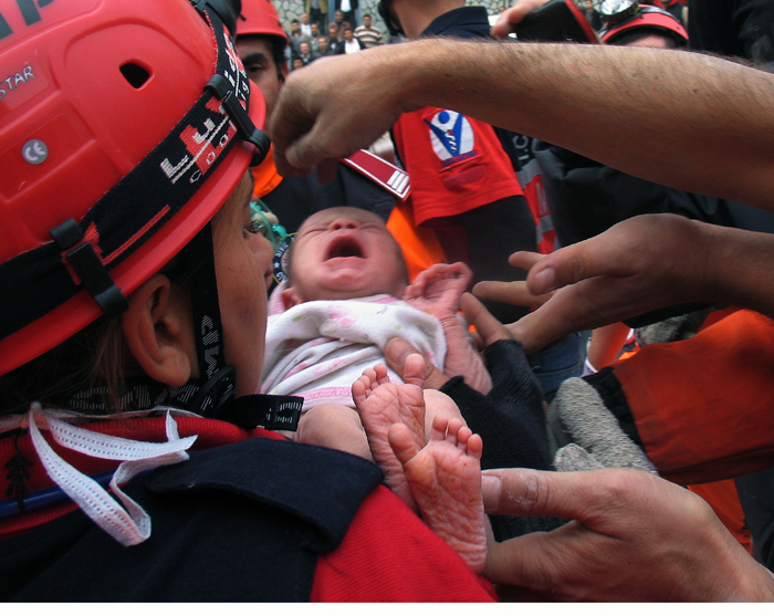 Turkish rescuers carry Azra Karaduman, a 2-week-old baby girl they saved today from under debris of a collapsed building in Ercis, Van, eastern Turkey.