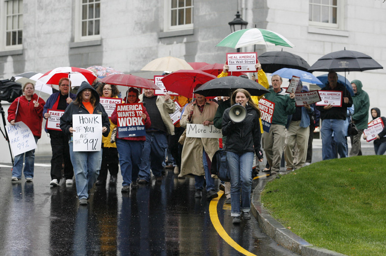 Protesters march from the State House to the federal building during a rally to encourage Congress to pass legislation to create jobs and enact a tax on all financial transactions Thursday in Augusta.