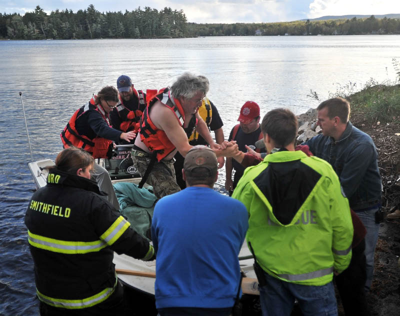 Staff photo by Michael G. Seamans Rescue personel from Oakland, Smithfield and Belgrade arrive at the shore with a victim of boat accident that occured on North Pond jus after 4pm Wednesday. The victim was transported ti Inland Hospital in Waterville.