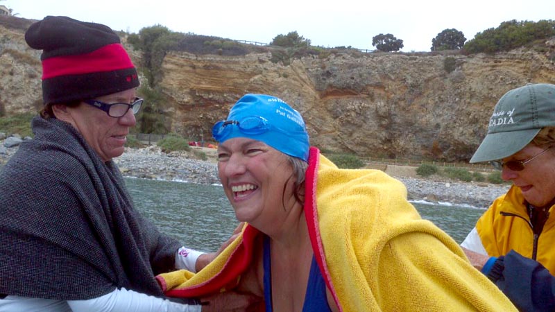 Friends assist Pat Gallant-Charette as she emerges from the water after swimming the Catalina Channel.
