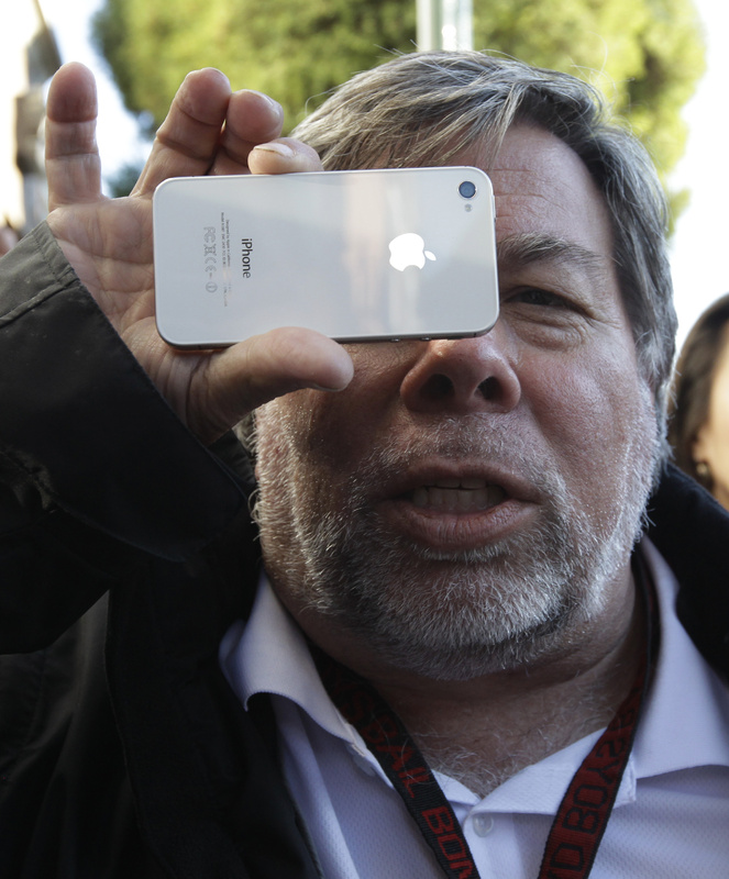 Apple co-founder Steve Wozniak holds up his new Apple iPhone 4S at the Apple store in Los Gatos, Calif., on Friday. He was first in line at the Los Gatos Apple store after arriving Thursday afternoon.