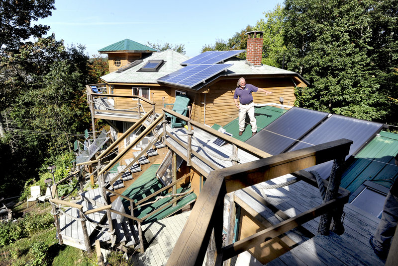 Michael Mayhew points out some of the solar panels gracing the many rooflines of his Boothbay Harbor home, a 1930s summer cottage that he has expanded and upgraded to the point where he gets about three-quarters of his yearly heat from the sun and pays a monthly electric bill of $10. Mayhew’s green home is among 58 Maine buildings featured in today’s Green Building Open House tour. Last year, more than 10,000 visitors checked out 500 homes from Maine to Pennsylvania.