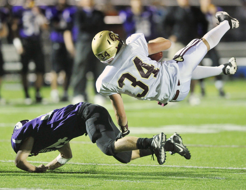 Nick Kenney, 34, who gained 107 yards rushing on 18 carries for Thornton Academy, heads to the ground Friday night after being upended by Kenny Sweet of Deering during Thornton’s 28-21 victory at Memorial Field.