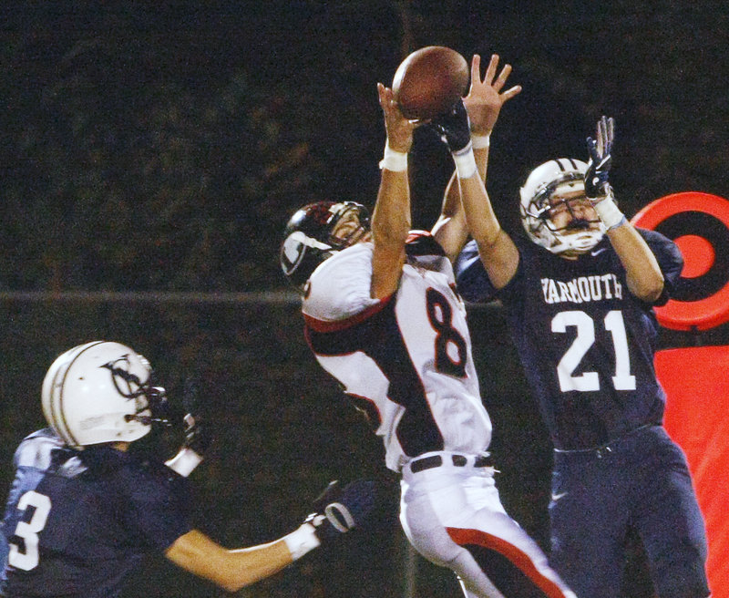 Bart Gallagher, right, of Yarmouth intercepts a pass intended for Lisbon’s Cam Graf while Dennis Erving helps defend. Gallagher had two interceptions that set up touchdowns in the Clippers’ 34-6 win Friday night.