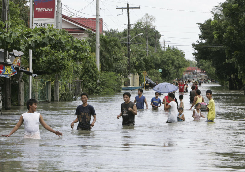 Residents wade through floodwaters in La Paz, Philippines, on Thursday, three days after Typhoon Nesat lashed the country. Typhoon Nalgae came ashore this morning.