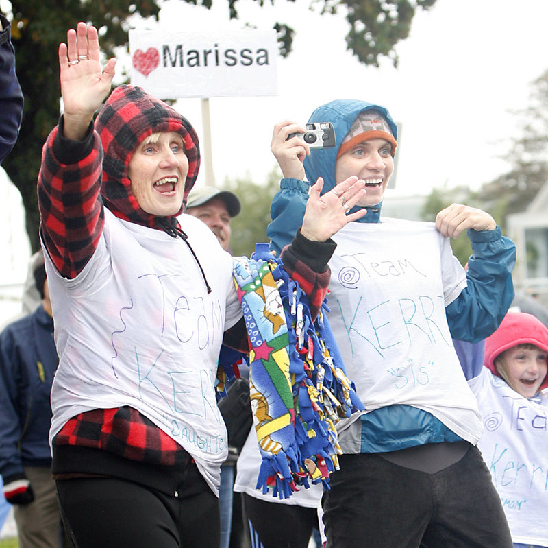 Wearing "Team Kerri" shirts, Nancy Russell of Brownville, left, and Megan Dean of Bangor cheer for Kerri Wiles during the Maine Marathon in Portland on Sunday. Russell is Kerri's mother and Dean is Kerri's sister.