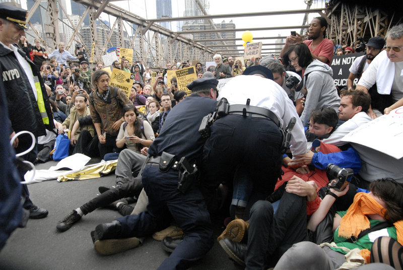 Police begin arresting the front line of protesters on New York's Brooklyn Bridge during Saturday's march by Occupy Wall Street. Demonstrators speaking out against corporate greed and other grievances attempted to walk over the bridge from Manhattan, resulting in the arrest of more than 700 during a tense confrontation with law enforcement.