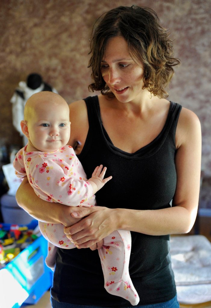 Kandace O’Neill of Lakeville, Minn., holds her 7-month-old daughter. Her 5-year-old son has had no shots since turning 1, and the baby has received no recommended vaccinations.