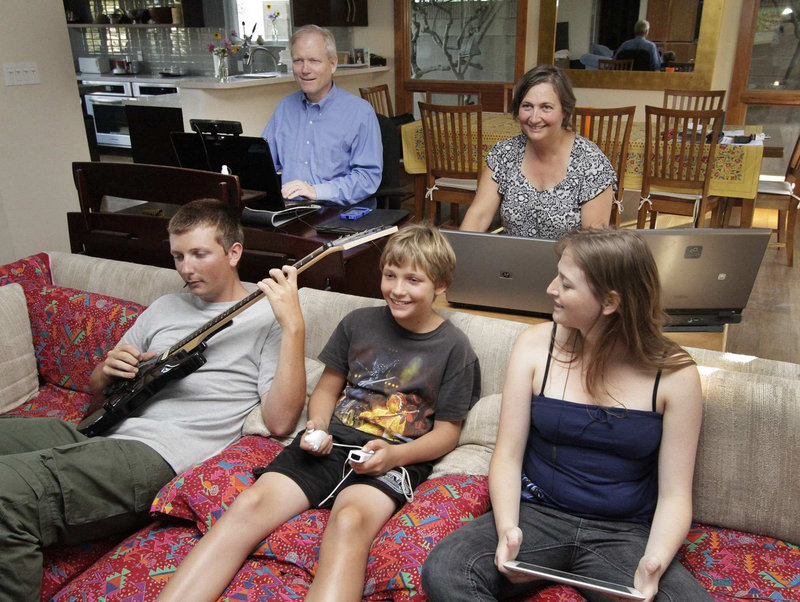 The Hartman family, parents Eric and Nia, rear, and their children, from left, sons Spencer, 16 and Evan, 11, and daughter Emily, 18, use digital devices that track their whereabouts, preferences and habits – a trend that concerns privacy advocates.