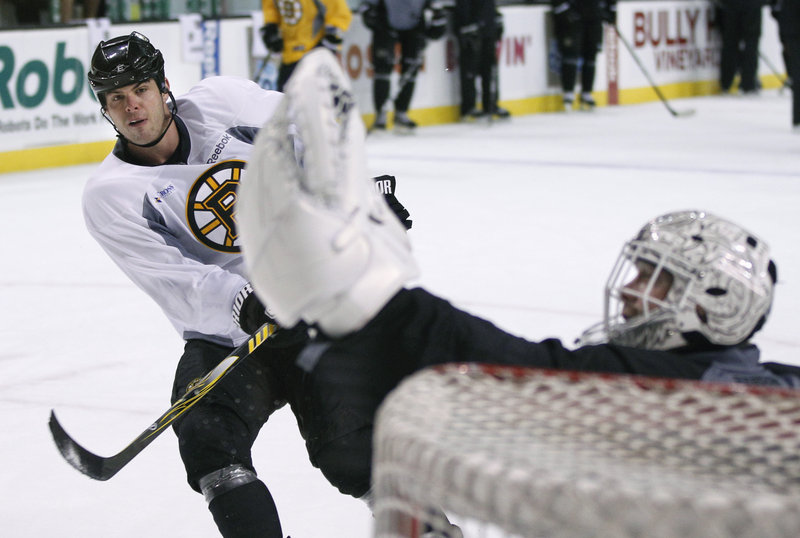 Goalie Tim Thomas makes a save on a shot by Nathan Horton at the Bruins’ final practice before today’s season opener.