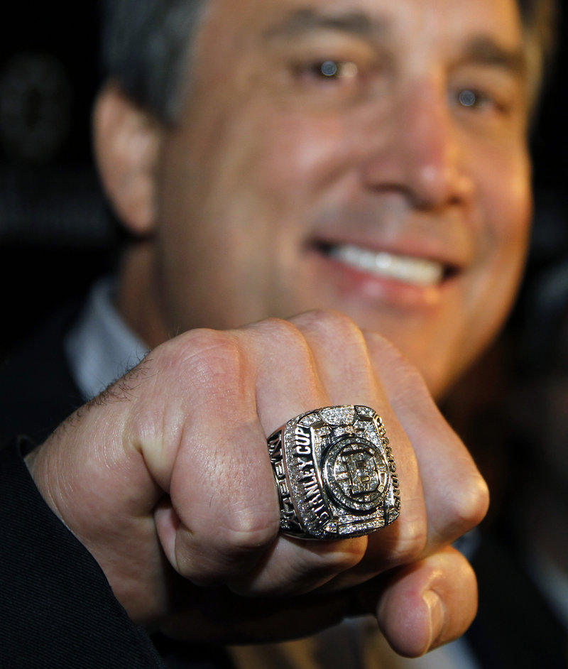Cam Neely, president of the Boston Bruins, displays his Stanley Cup championship ring to members of the media in Boston on Tuesday.